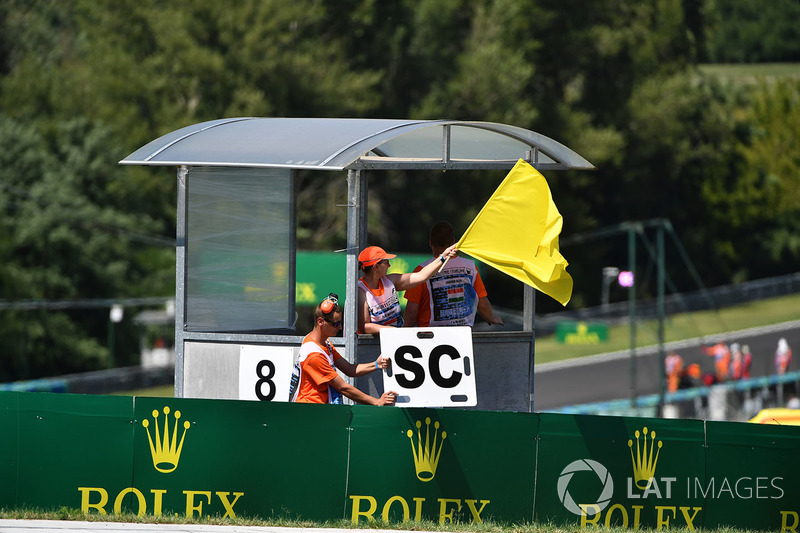 Un marshal sventola la bandiera gialla e il cartello della Safety Car