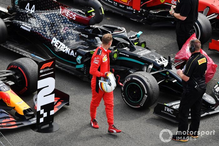 Sebastian Vettel, Ferrari, observa el neumático pinchado del monoplaza de Lewis Hamilton, Mercedes F1 W11, en Parc Ferme