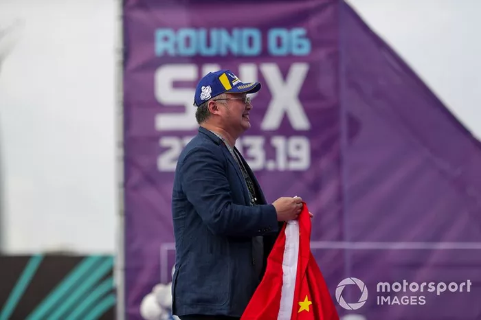 A DS TECHEETAH representative on the podium with a flag of the Peoples' Republic of China