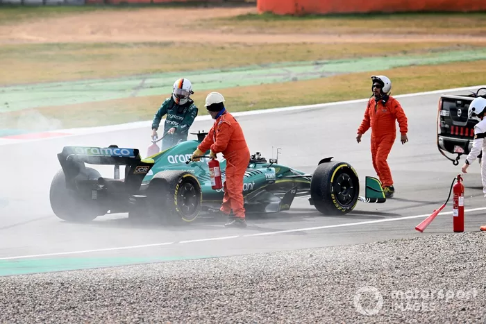 Marshals assist Sebastian Vettel, Aston Martin AMR22, after a technical failure results in smoke