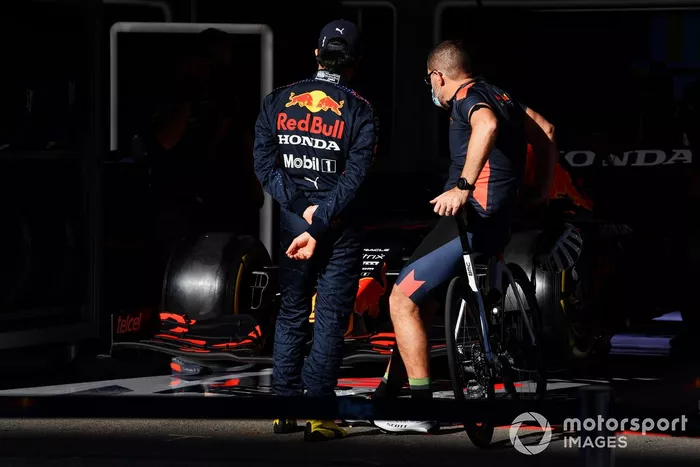 Sergio Perez, Red Bull Racing, con un miembro del equipo fuera del box