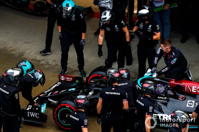 Miembros del equipo Mercedes trabajan en el coche de Lewis Hamilton, Mercedes W12, en el pit lane