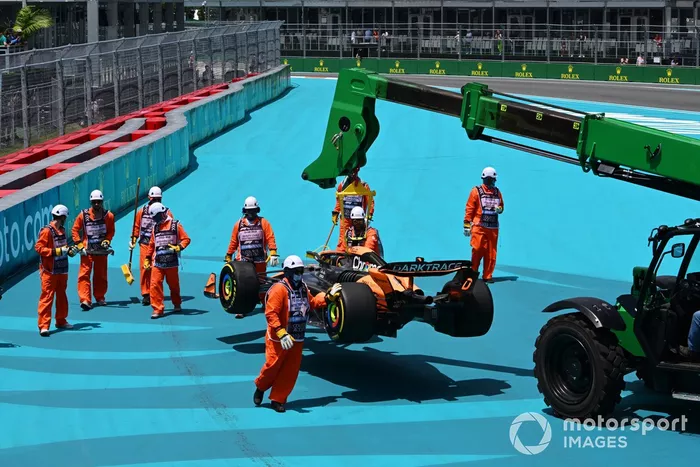 Los comisarios retiran el coche de Lando Norris, McLaren MCL38, después de que hiciera un trompo en la primera vuelta
