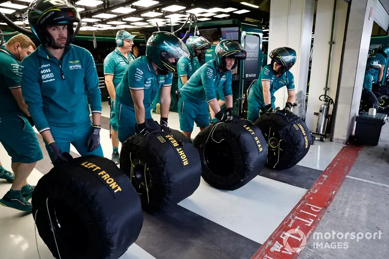 L'équipe des stands d'Aston Martin attend avec les pneus dans le garage. 