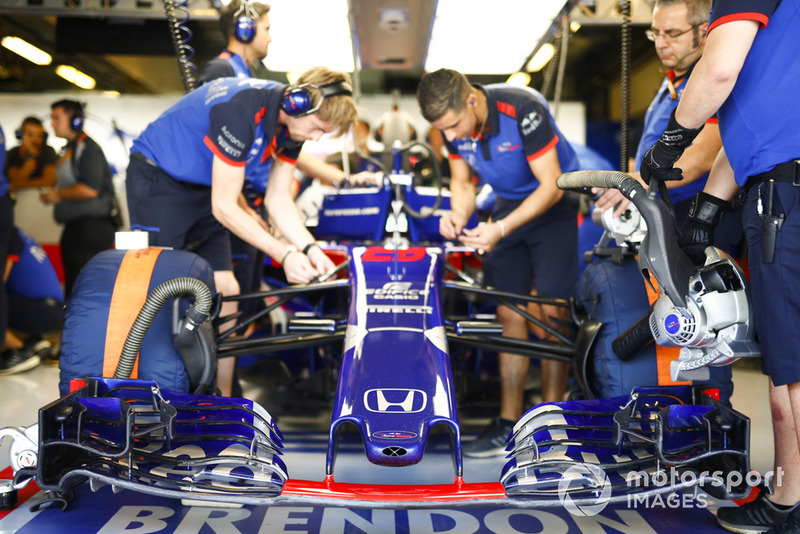 Mechanics work on the car of Brendon Hartley, Toro Rosso STR13, in the garage