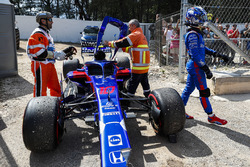 Marshals remove the damaged car of Pierre Gasly, Toro Rosso STR13, as he walks away