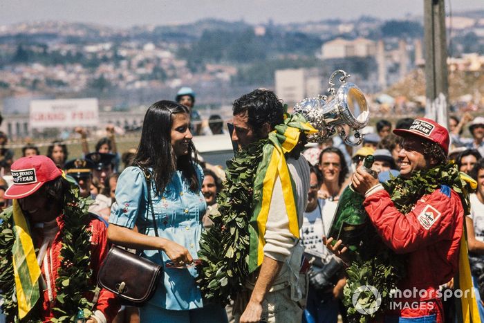 Carlos Pace celebra a vitória no pódio com Emerson Fittipaldi, 2º classificado, e Jochen Mass, 3º classificado