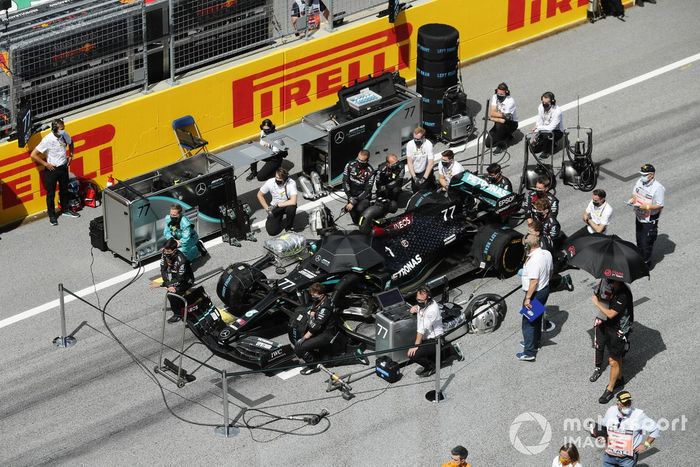 Los ingenieros y mecánicos de Mercedes se ponen de rodillas en la parrilla