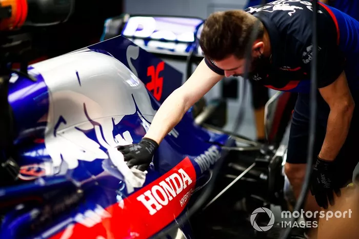 Un mecánico de Toro Rosso limpia la cubierta de un motor
