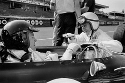 Dan Gurney, Eagle AAR104 Weslake in the pitlane talking to teammate Bruce McLaren, Eagle AAR102 Weslake