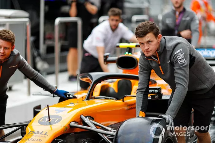 Meccanici della McLaren spingono la McLaren MCL34 di Lando Norris 