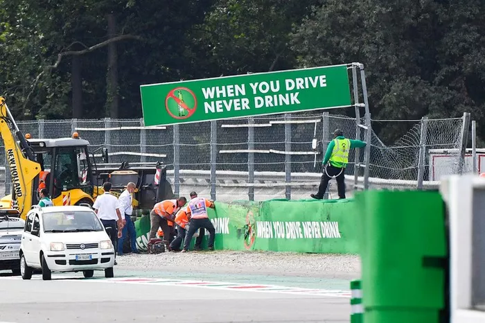 Los comisarios reparan las protecciones de la curva de Monza donde Alex Peroni, de Campos Racing, sufrió un accidente
