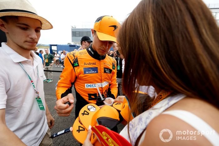 El polaco Lando Norris, del equipo McLaren F1, firma autógrafos para los aficionados