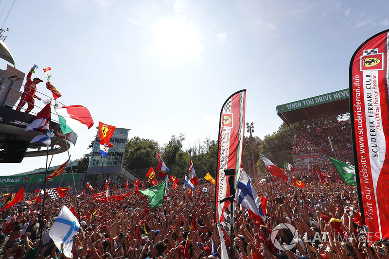 A sea of red clothes and red smoke gathers around the podium to cheer for Third place Sebastian Vettel, Ferrari