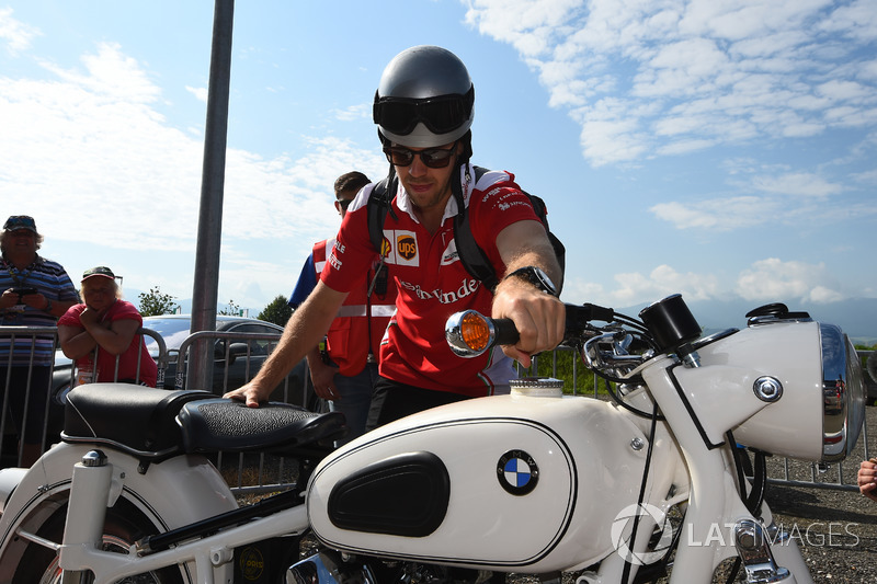 Sebastian Vettel, Ferrari llega al circuito en su moto vintage BMW.