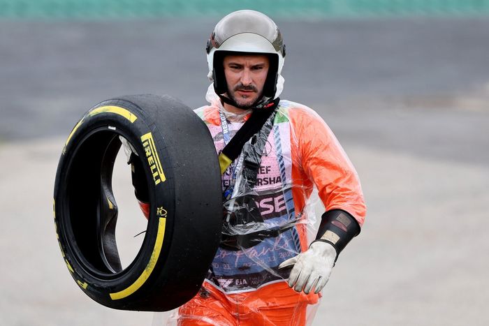 Marshal recovers a tyre carcass from the track