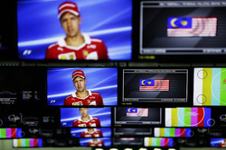 Sebastian Vettel, Ferrari, is pictured on television screens in the media centre