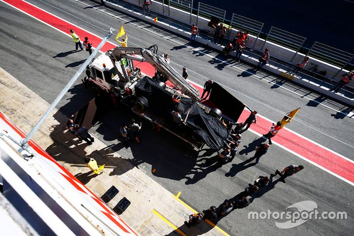 El McLaren MCL32 de Fernando Alonso vuelve al pitlane en un camión