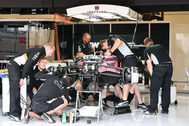 Mecánicos alrededor del VJM10 preparando el monoplaza en su garaje para los entrenamientos libres.
