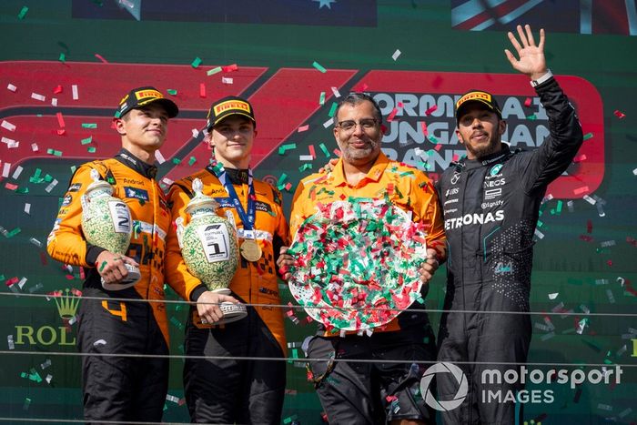 Lando Norris, McLaren F1 Team, 2ª posición, Oscar Piastri, McLaren F1 Team, 1ª posición, el delegado del trofeo McLaren y Lewis Hamilton, Mercedes-AMG F1 Team, 3ª posición, en el podio.