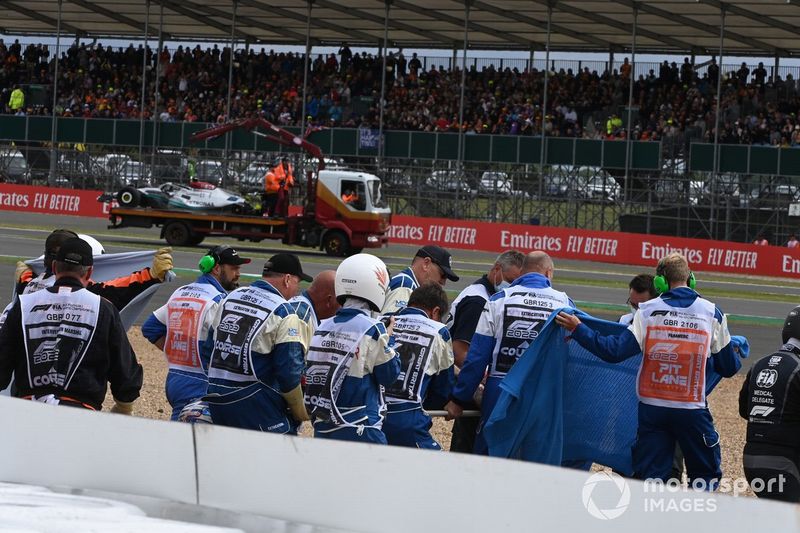 Los oficiales de pista extraen a Zhou Guanyu, del equipo Alfa Romeo F1, de su coche dañado tras un accidente al inicio
