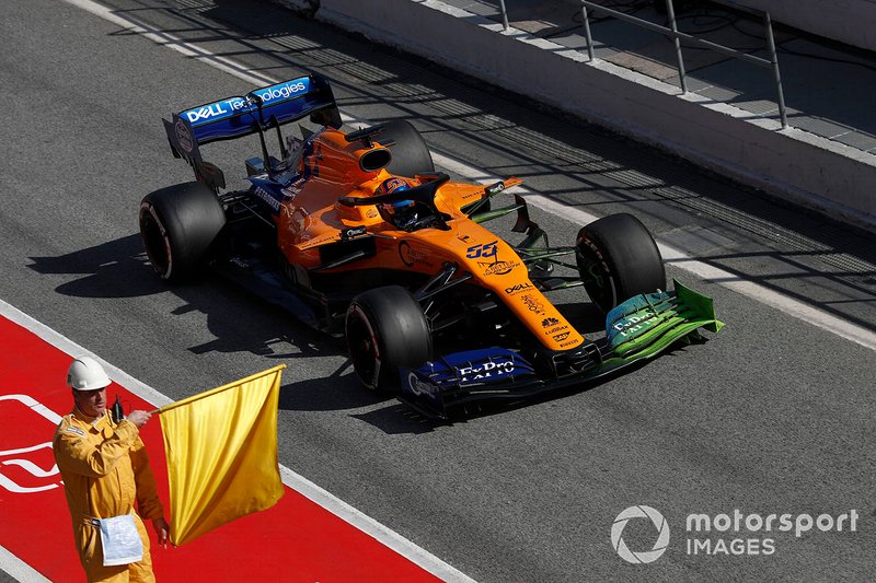 Carlos Sainz Jr., McLaren MCL34, accanto a un commissario con una bandiera gialla