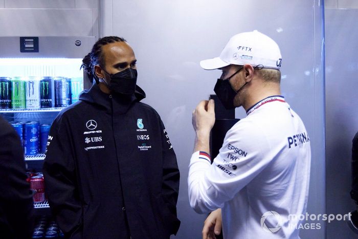 Lewis Hamilton, de Mercedes, y Valtteri Bottas, de Mercedes, hablan en el garaje