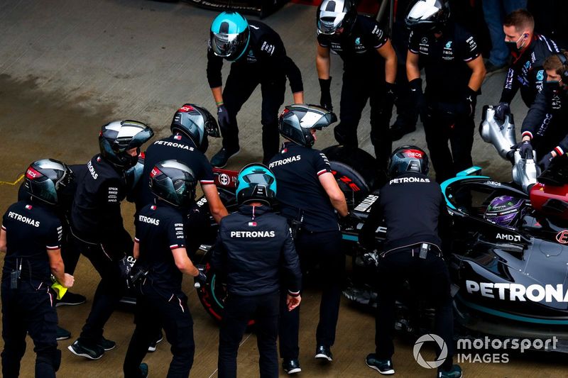 Miembros del equipo Mercedes trabajan en el coche de Lewis Hamilton, Mercedes W12, en el pit lane