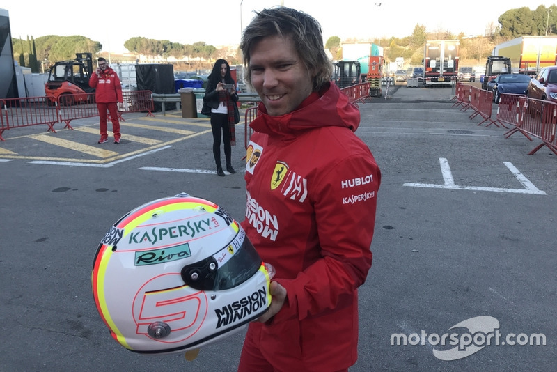 Antti Kontsas memegang helm Sebastian Vettel