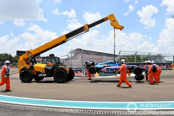 Los oficiales de pista trasladan el coche dañado de Esteban Ocon, Alpine A522, tras un accidente