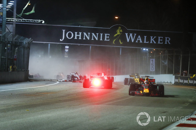 Daniel Ricciardo, Red Bull Racing RB13, passes Sebastian Vettel, Ferrari SF70H, as the latter crashe