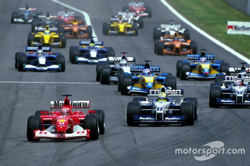 The start of the race and Michael Schumacher, Ferrari, leads Ralf Schumacher, Williams BMW FW24,  Juan Pablo Montoya, Williams BMW FW24