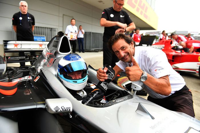 Mika Hakkinen, McLaren MP4-13 y Jean-Michel Tibi, FOM Camarógrafo en Leyendas F1 30 Aniversario vuelta de Demostración