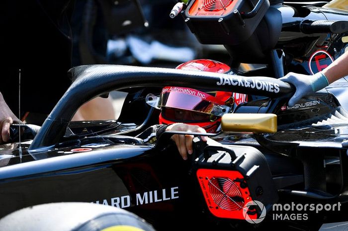 Los mecánicos mueven el coche de Kevin Magnussen, Haas F1 Team VF-19