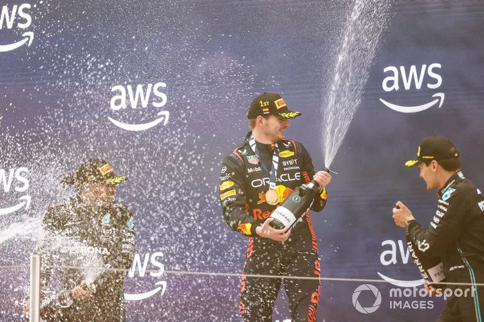 Lewis Hamilton, Mercedes-AMG, 2ª posición, Max Verstappen, Red Bull Racing, 1ª posición, George Russell, Mercedes-AMG, 3ª posición, spray de Champagne en el podio.