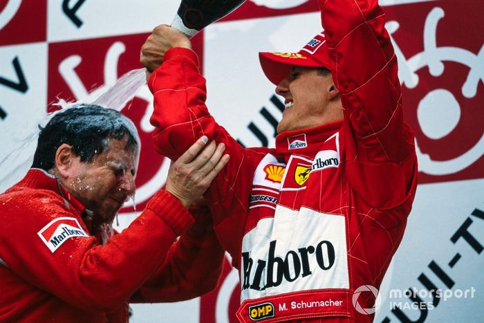 Michael Schumacher, 1er puesto, vierte champán sobre Jean Todt, director de la escudería Ferrari, en el podio después de asegurar el campeonato mundial.