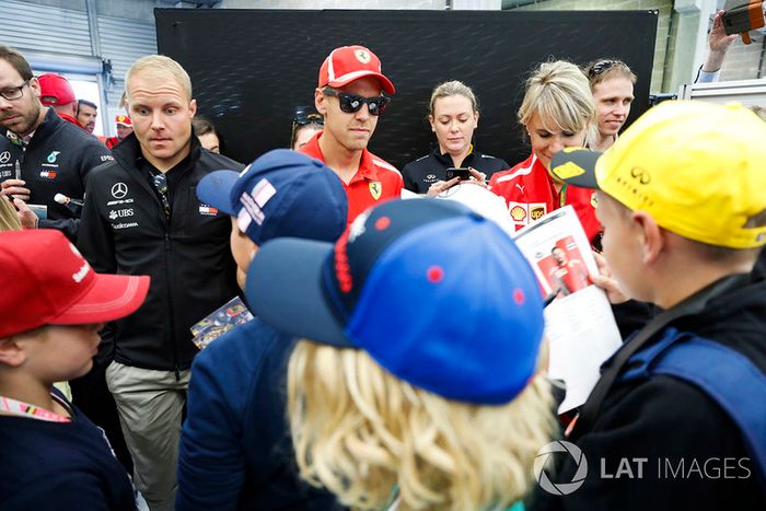 Valtteri Bottas, Mercedes AMG F1, y Sebastian Vettel, Ferrari, firma autógrafos para niños