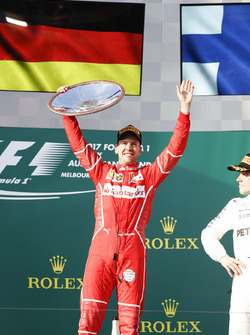 Sebastian Vettel, Ferrari, vainqueur, lève son trophée sur le podium