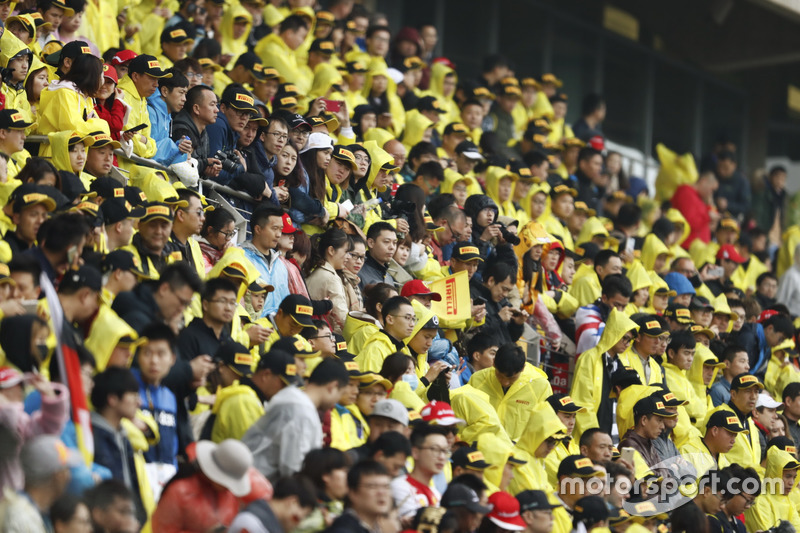 Crowds in yellow Pirelli macs in the grandstands