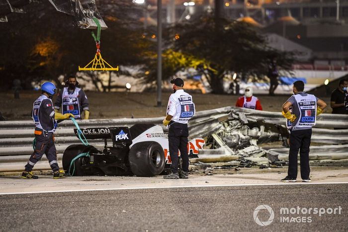 Los restos quemados del monoplaza de Romain Grosjean, Haas VF-20 y la barrera dañada