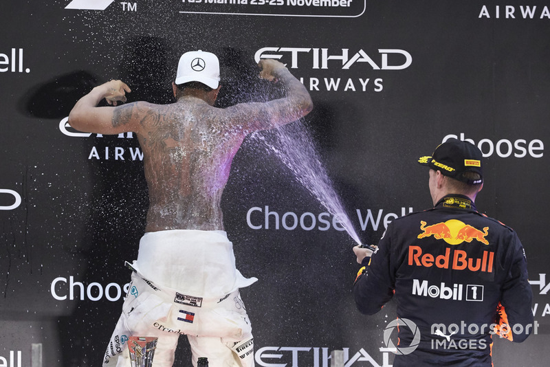 Lewis Hamilton, Mercedes AMG F1, 1st position, strips to the waist as Max Verstappen, Red Bull Racing, 3rd position, sprays him in celebration with Rose Water