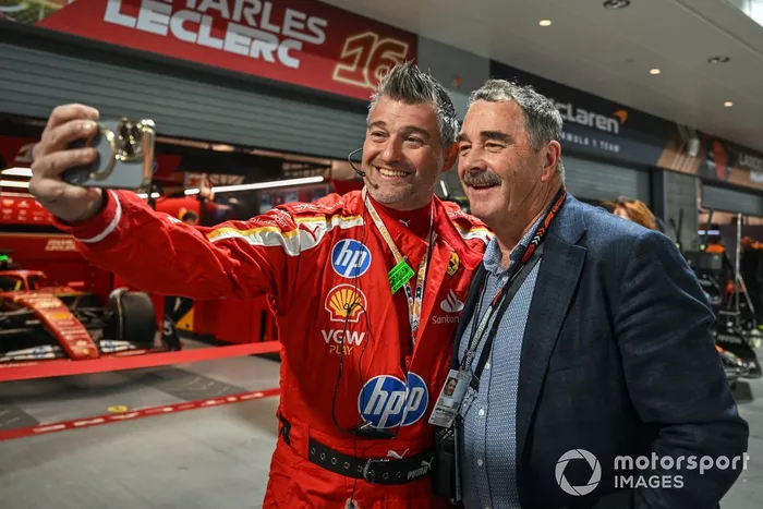 Nigel Mansell poses for a picture with a Scuderia Ferrari team member
