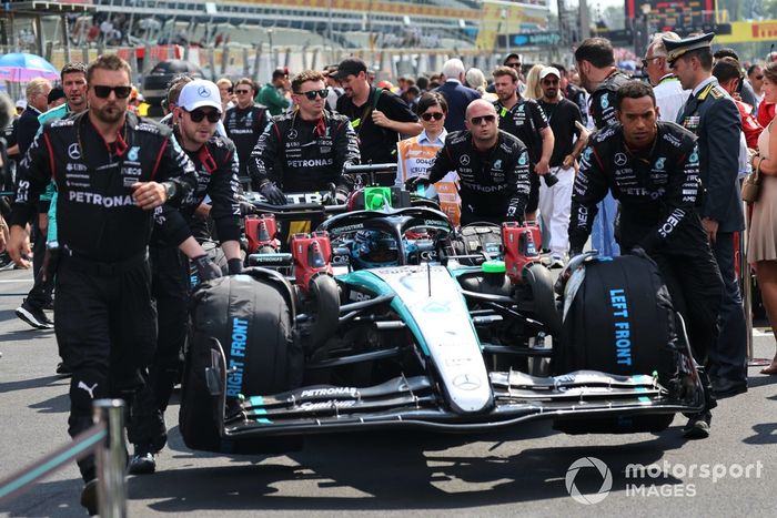 Los mecánicos empujan a George Russell, Mercedes F1 W15, a su puesto en parrilla