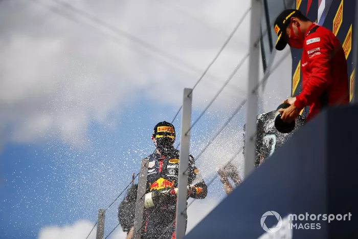 Max Verstappen, Red Bull Racing, secondo posto, Lewis Hamilton, Mercedes-AMG F1, primo posto, e Charles Leclerc, Ferrari, terzo posto, festeggia sul podio con lo champagne