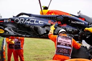 Los comisarios retiran el coche dañado de Sergio Pérez, Red Bull Racing RB20