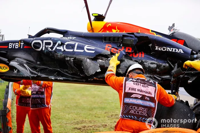 Los comisarios retiran el coche dañado de Sergio Pérez, Red Bull Racing RB20