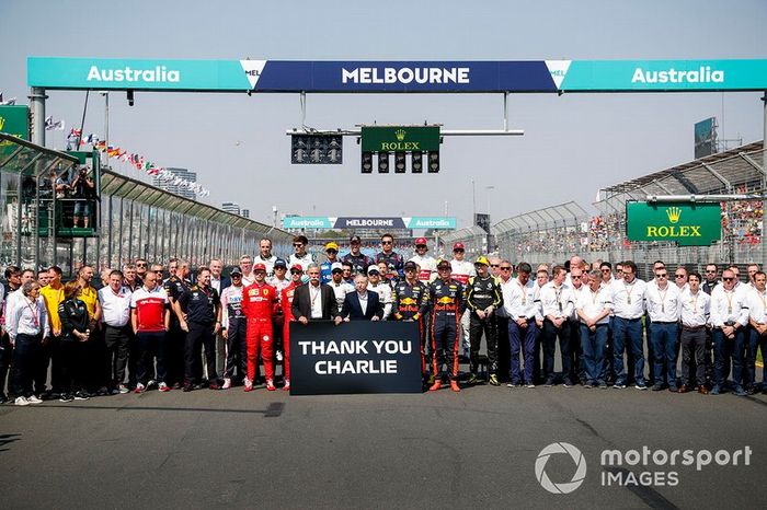 Los pilotos y el personal del equipo se reúnen detrás de Chase Carey, Presidente, Fórmula 1 y Jean Todt, Presidente, FIA, que sostienen un cartel que recuerda a Charlie Whiting.