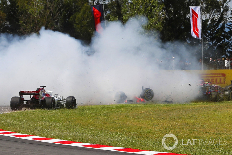 Pierre Gasly, Toro Rosso STR13, and Nico Hulkenberg, Renault Sport F1 Team R.S. 18, collect the spinning Romain Grosjean, Haas F1 Team VF-18