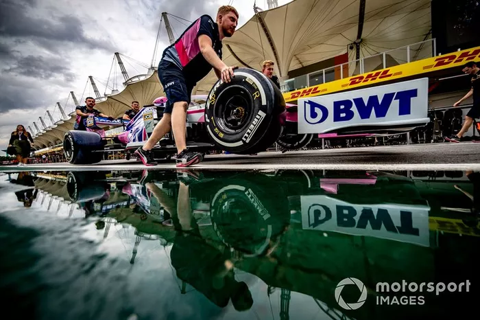 Los mecánicos de Racing Point empujan el coche de Sergio Pérez, Racing Point RP19 por el pit lane