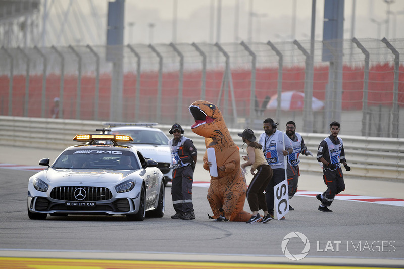 Marshals with a message for Charlie Whiting, FIA Delegate in the Safety car involving a dinasour